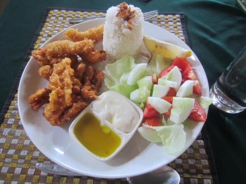 einen Teller mit Reis und Gemüse auf dem Tisch in der Unterkunft Villa Selina in Tejakula