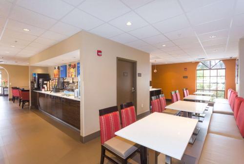 un restaurant avec des tables, des chaises et un comptoir dans l'établissement Baymont by Wyndham Bonita Springs, à Bonita Springs