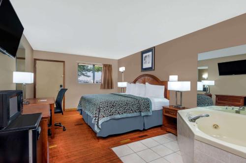ein Hotelzimmer mit einem Bett und einer Badewanne in der Unterkunft Days Inn by Wyndham Maumee/Toledo in Maumee
