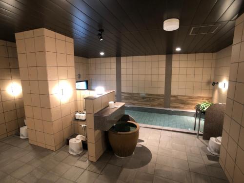 La salle de bains est pourvue d'une piscine et de toilettes. dans l'établissement Hotel Route-Inn Tsuchiura, à Tsuchiura