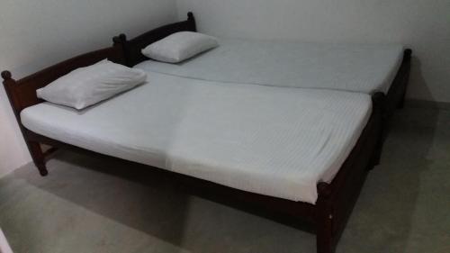 two beds with white sheets and pillows on them at Shining Line in Koggala