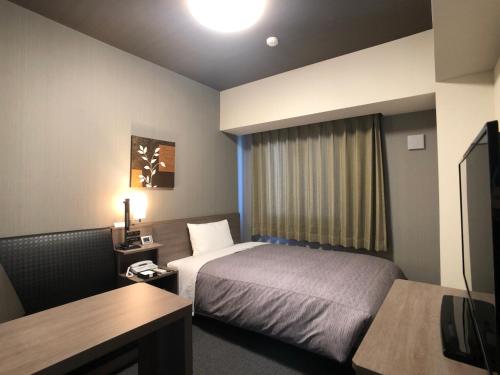 Hotel Route-Inn Tsuchiura tesisinde bir odada yatak veya yataklar