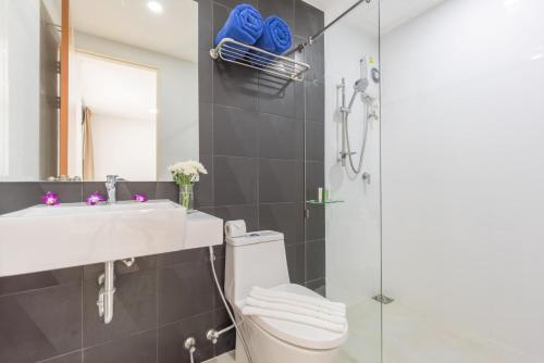 ein Bad mit einer Dusche, einem WC und einem Waschbecken in der Unterkunft Ozone Condotel in Kata Beach