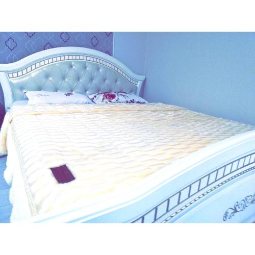 1 cama con colchón blanco y cabecero de madera en Best apartment on Sauran Towers, en Astana