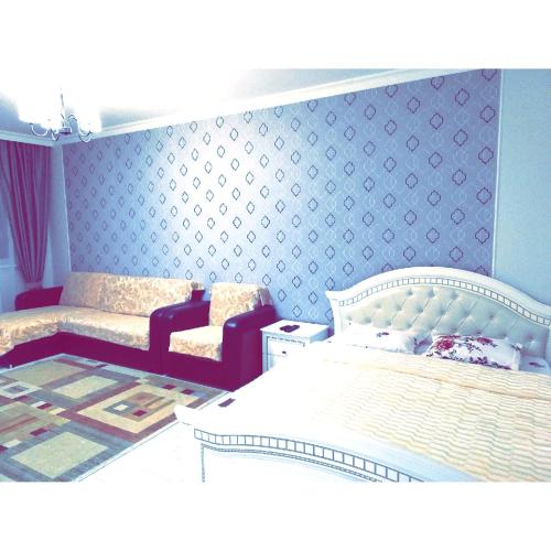 1 dormitorio con cama blanca y pared azul en Best apartment on Sauran Towers, en Astana