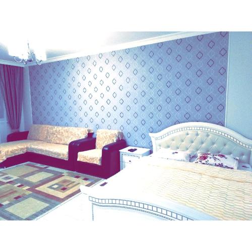 a bedroom with a white bed and a blue wall at Best apartment on Sauran Towers in Astana