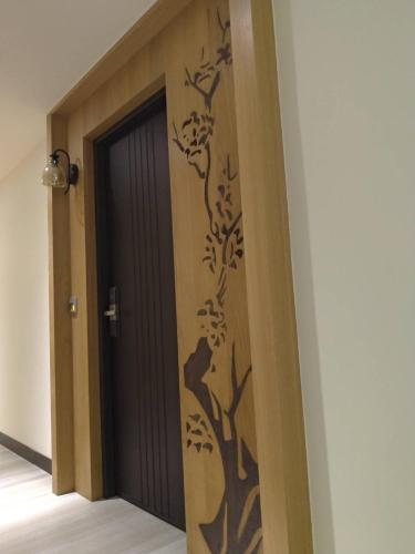a door with a tree mural on the wall at Lantan Fanyue Inn in Chiayi City