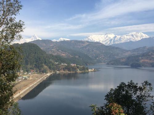 a view of a lake with snow covered mountains at Mount Fuji Homestay in Deorāli