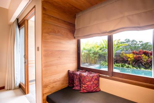 Habitación con ventana y banco con almohadas en Ulun Ubud Resort - CHSE Certified, en Ubud