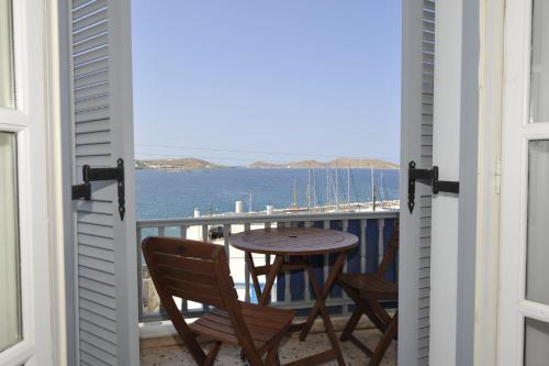 balkon ze stołem i krzesłami oraz widokiem na ocean w obiekcie Flora Rooms & Apartments w mieście Nausa