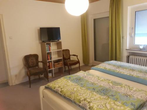 バート・ザルツフレンにあるTal-Residenz Haus Nr 5のベッドルーム1室(ベッド2台、テレビ、椅子2脚付)