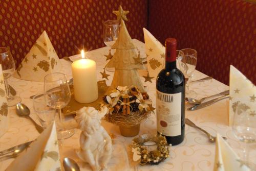 a table with a bottle of wine and a candle at Hotel Bräuwirt in Kirchberg in Tirol