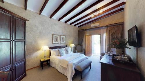 a bedroom with a large bed and a large window at Ancient Emperor Guest Estate in Potchefstroom