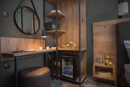 a room with a desk and a stool and a mirror at The Stay by Aston Hotel Central Square - Free Compliments - Free Wi-Fi - TOP LOCATION - Nearby Paid Parking in Plovdiv