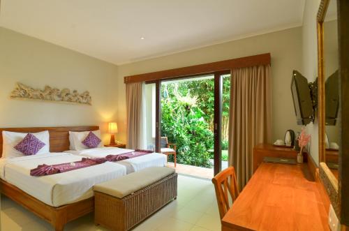 a bedroom with a bed and a sliding glass door at Bumi Muwa Ubud at Monkey Forest in Ubud