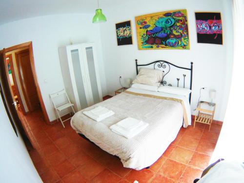 um quarto com uma cama e um quadro na parede em Casa junto a Itálica em Santiponce