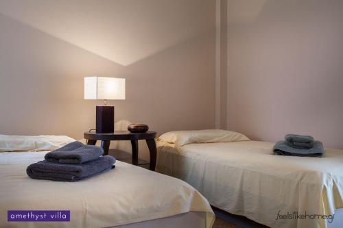 two beds with towels on top of them in a room at Afitos Hidden Gems #FeelsLikeHome in Afitos