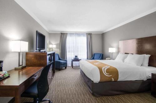 a hotel room with a large bed and a desk at Quality Inn Downtown Inner Harbour in Victoria