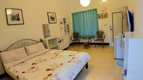 a bedroom with a bed and a table and chairs at 悦來民宿 台東縣民宿334號 in Taiping