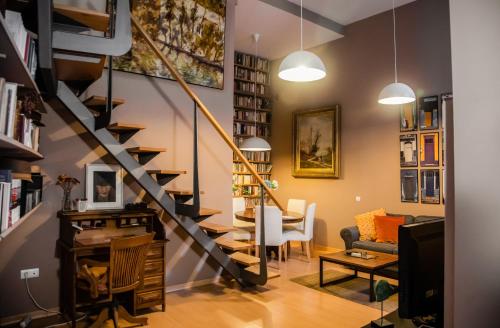 a living room with a staircase and a dining room at Abades Giralda View by Valcambre in Seville