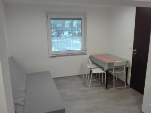jadalnia ze stołem i krzesłami oraz oknem w obiekcie Trenta Apartman Bükfürdő w mieście Bük