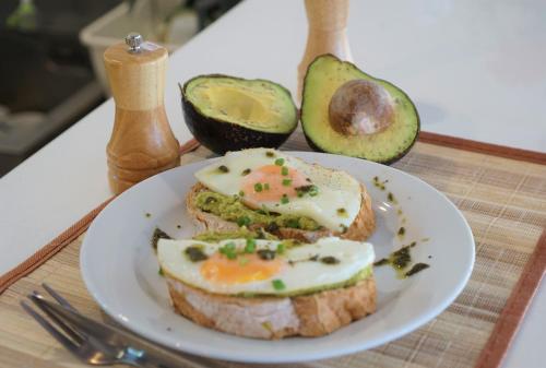 a plate of food with an egg sandwich and avocado at Morning Star Resort in Baan Tai