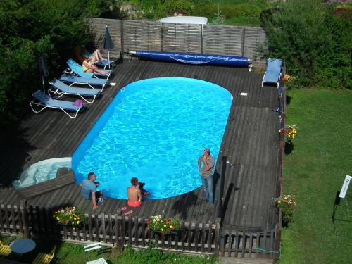 a group of people standing around a swimming pool at La Girandole Chambre d'hôtes et Location d'appartement in Arvieux