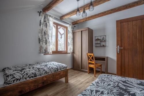 a bedroom with a bed and a desk and a window at APARTAMENTY ZAZAMCZE in Muszyna