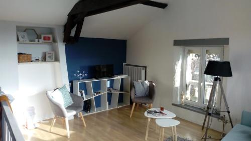 un salon avec un mur et des chaises bleu dans l'établissement Maison Cahors, à Cahors