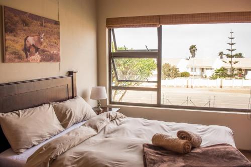 1 dormitorio con 1 cama con una foto de caballo en la pared en Sea View Bliss Guesthouse with self Catering, en Swakopmund