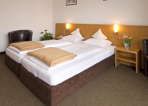 a large bed with two pillows on it in a room at Hotel Bräuwirt in Kirchberg in Tirol