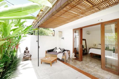 a living room with a bed and a bathroom at The Apartments Canggu in Canggu
