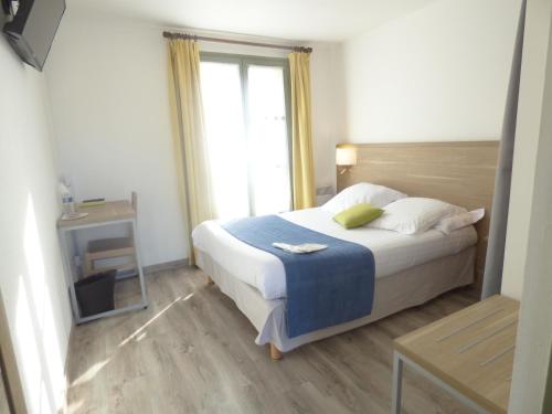 Un dormitorio con una cama grande y una ventana en Hôtel Les Comtes de Pardiac, en Marciac