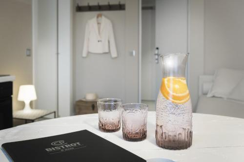 two glasses and a vase with an orange on a table at CP Resort in Taverne