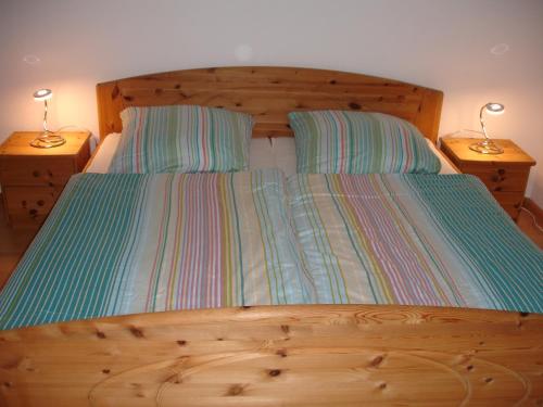a wooden bed with two lamps on two night stands at Ferienwohnung Umkirch in Umkirch