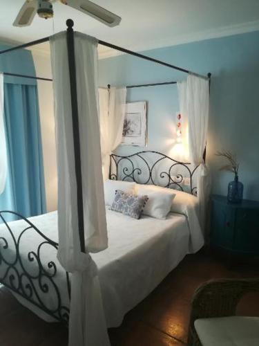 a bedroom with a canopy bed with white curtains at Hotel Macavi Playa in Rota