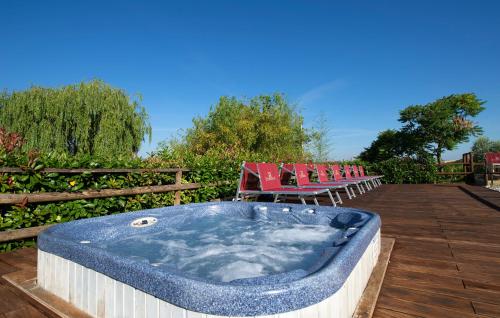 a hot tub sitting on a wooden deck with chairs at Borgo Filicardo in Montespertoli