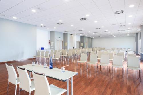 a room with white tables and white chairs at Hotel Guadalajara & Conference Center Affiliated by Meliá in Guadalajara