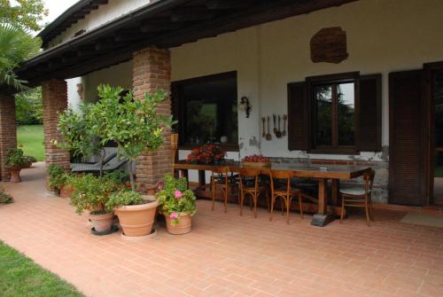een terras met een tafel, stoelen en planten bij B&B Soiano Del Lago in Soiano del Lago