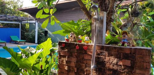 a brick wall with a shower in a garden at 2 Home in Chalong 