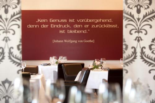 a room with tables and chairs with a sign on the wall at Le Temple in NeuhÃ¼tten