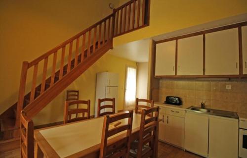 une cuisine avec un escalier, une table et des chaises dans l'établissement Camping l'Air du Lac***, à Saint-Hilaire-les-Places