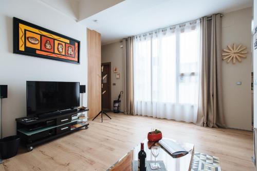 a living room with a television and a table at Mi Rincon Central Apartment in Seville