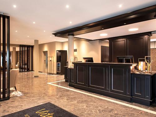 a tasting room with black cabinets and a lobby at Victor's Residenz-Hotel Teistungenburg in Teistungen