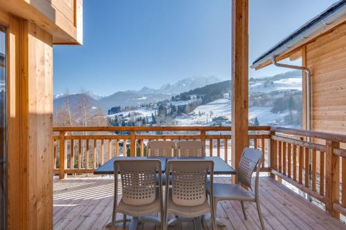 a table and chairs on a deck with a view at TERRESENS - Les Fermes du Mont-Blanc in Combloux