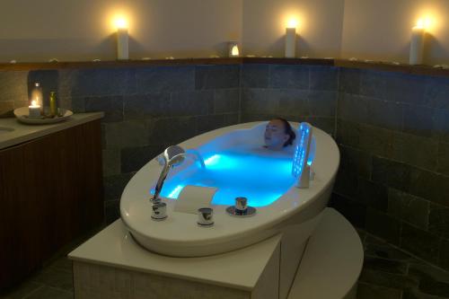 a bathroom with a bath tub with a man in it at Sunrise Pearl Hotel & Spa in Protaras