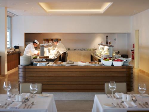 two chefs preparing food in a restaurant kitchen at Sunrise Pearl Hotel & Spa in Protaras