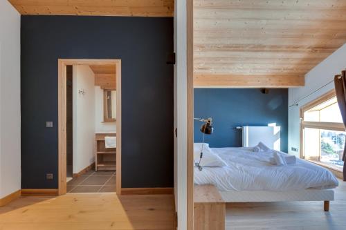 a bedroom with a bed and a blue wall at TERRESENS - Les Fermes du Mont-Blanc in Combloux