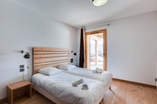 a bedroom with two beds and a large window at TERRESENS - Les Fermes du Mont-Blanc in Combloux