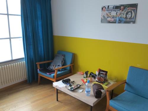 Zimmer mit einem Tisch, 2 Stühlen und einem Tisch in der Unterkunft Basel Backpack in Basel